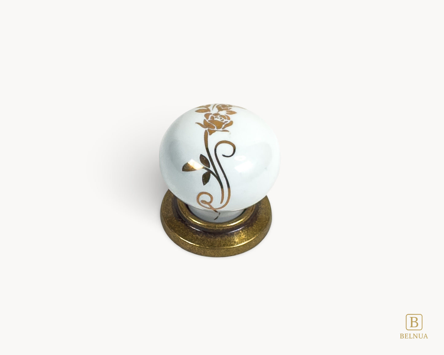 Belnua - Top view of ZERRA white ceramic/porcelain knob with golden scroll motif and antique brass base