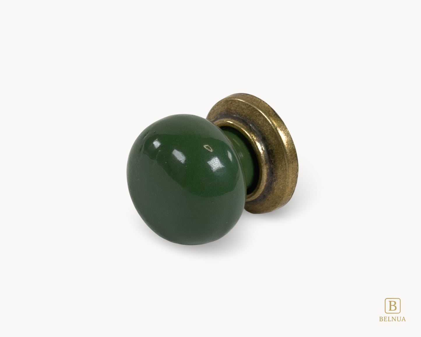Belnua - Left angled flat lay of antique brass knob with dark green porcelain insert from Zerra collection