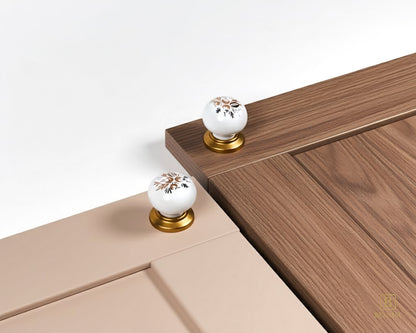 Belnua - ZERRA porcelain/ceramic white knob with golden arch bloom motif showcasing with soft pink and mocha wood grain cabinet door