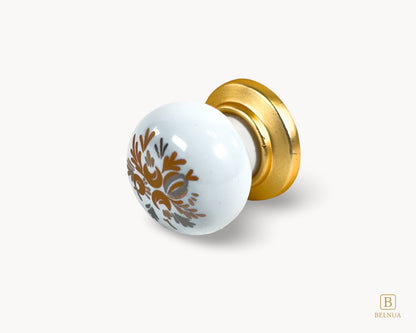 Belnua - Flat lay detailed right side view of delicate ZERRA white cabinet porcelain/ceramic knob with matte gold finish and golden arch motif