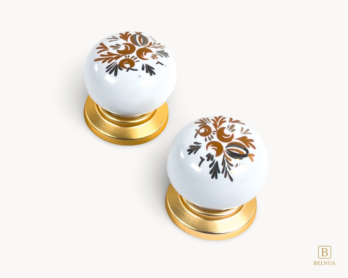 Belnua - Close up top view of ZERRA white cabinet porcelain/ceramic knob with matte gold finish and golden arch motif