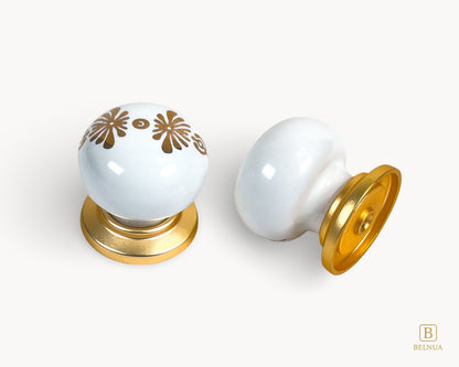 Belnua - Top and right back angled view of ZERRA matte gold knob with white floral porcelain