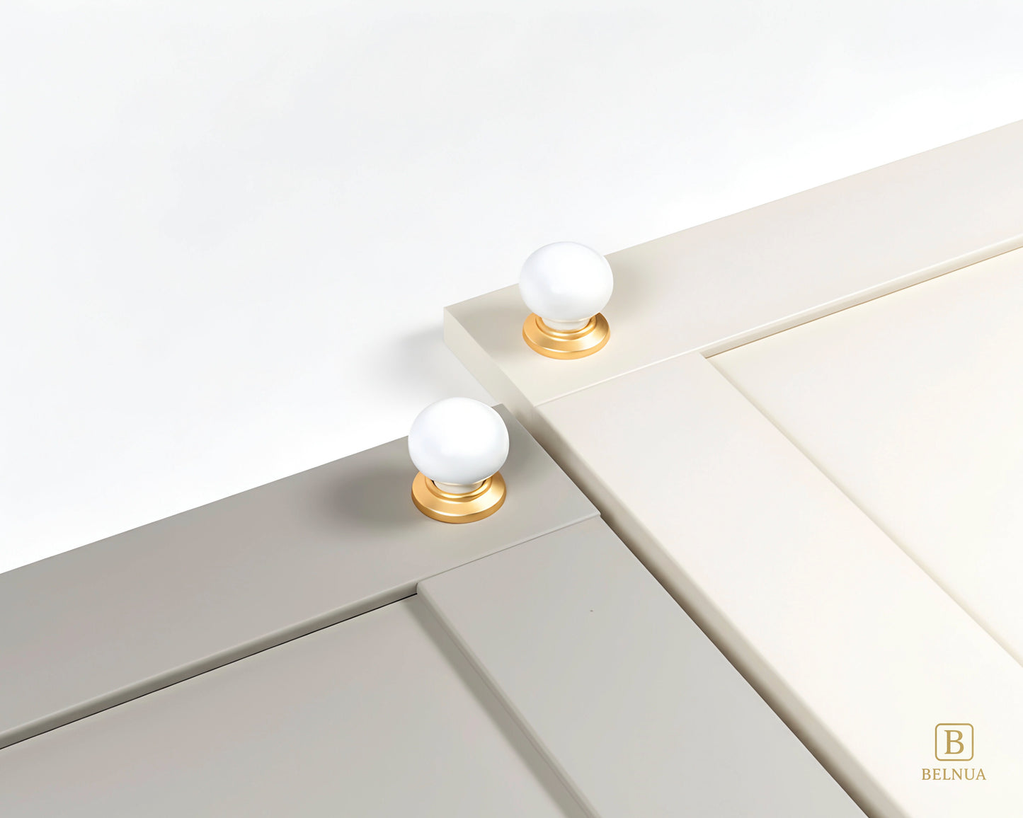 Close-up of a stone grey and cashmere cabinet doors with Zerra white ceramic knobs and gold bases | Belnua