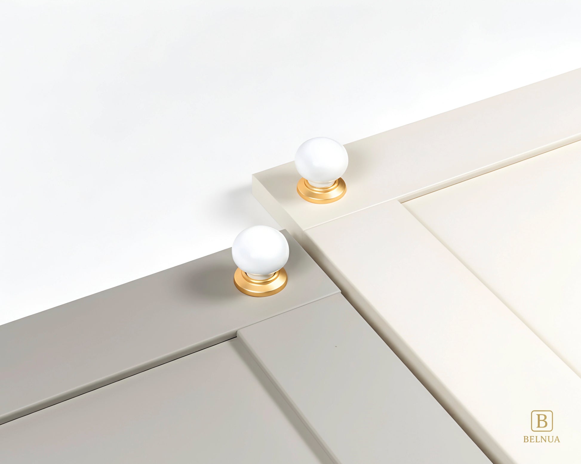Close-up of a stone grey and cashmere cabinet doors with Zerra white ceramic knobs and gold bases | Belnua