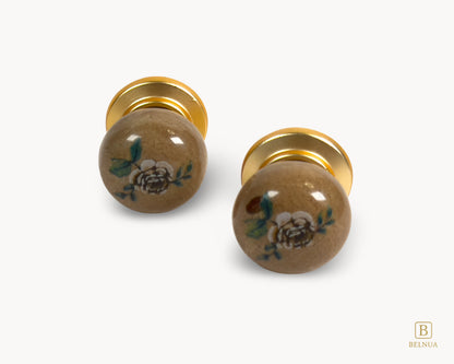 Belnua - Flat lay front close up view of delicate ZERRA ceramic.porcelain knob pair showing matte gold finish and rose motif