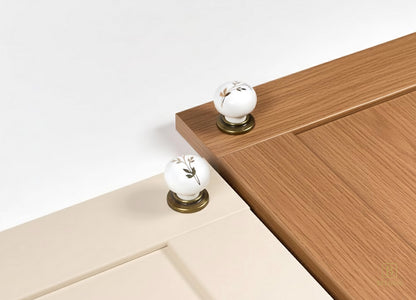 Close-up of cream and oak cabinet doors with Zerra white ceramic/porcelain floral knobs | Belnua