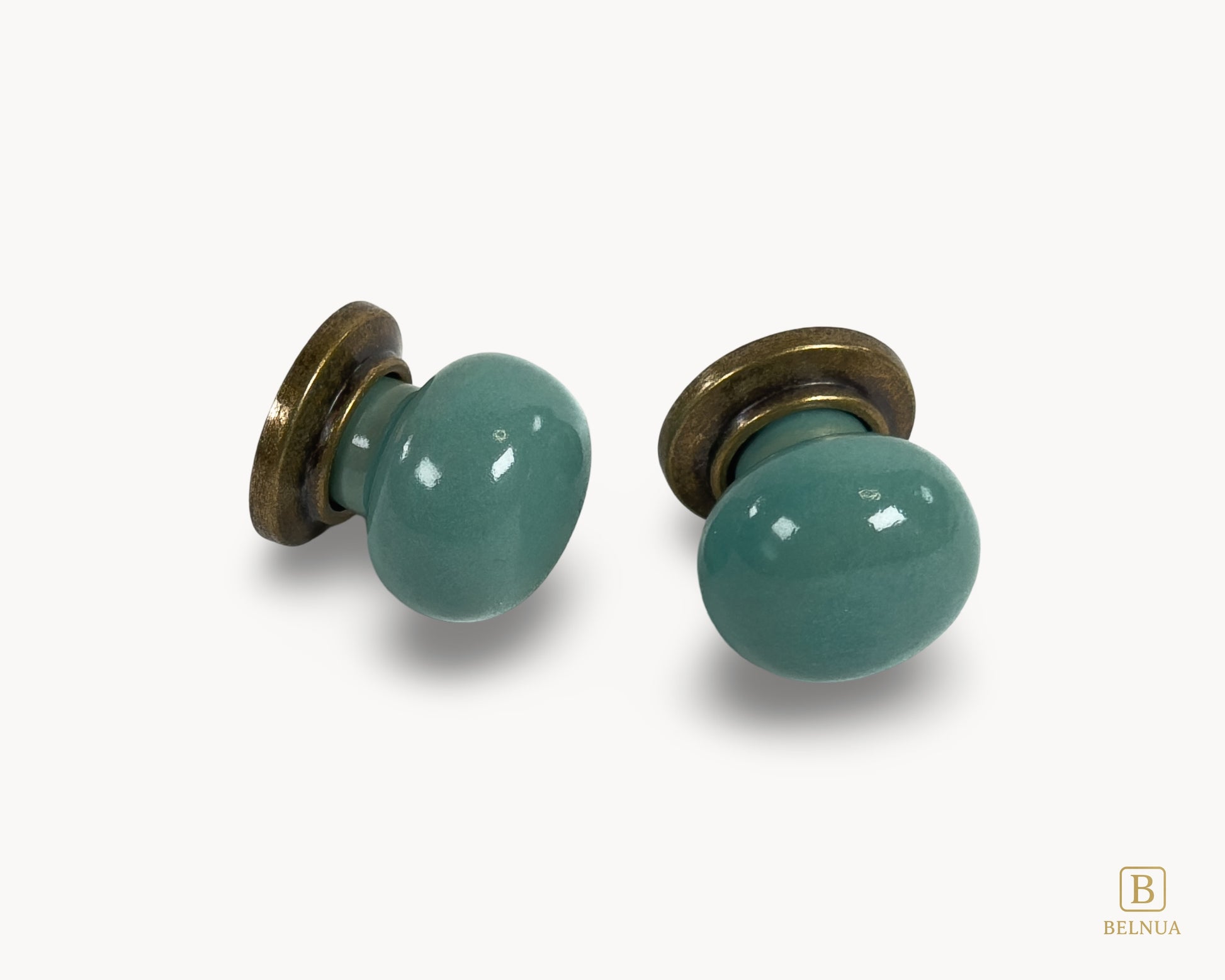 Front angled flat lay view of Zerra turquoise ceramic cabinet knobs with brass hardware | Belnua
