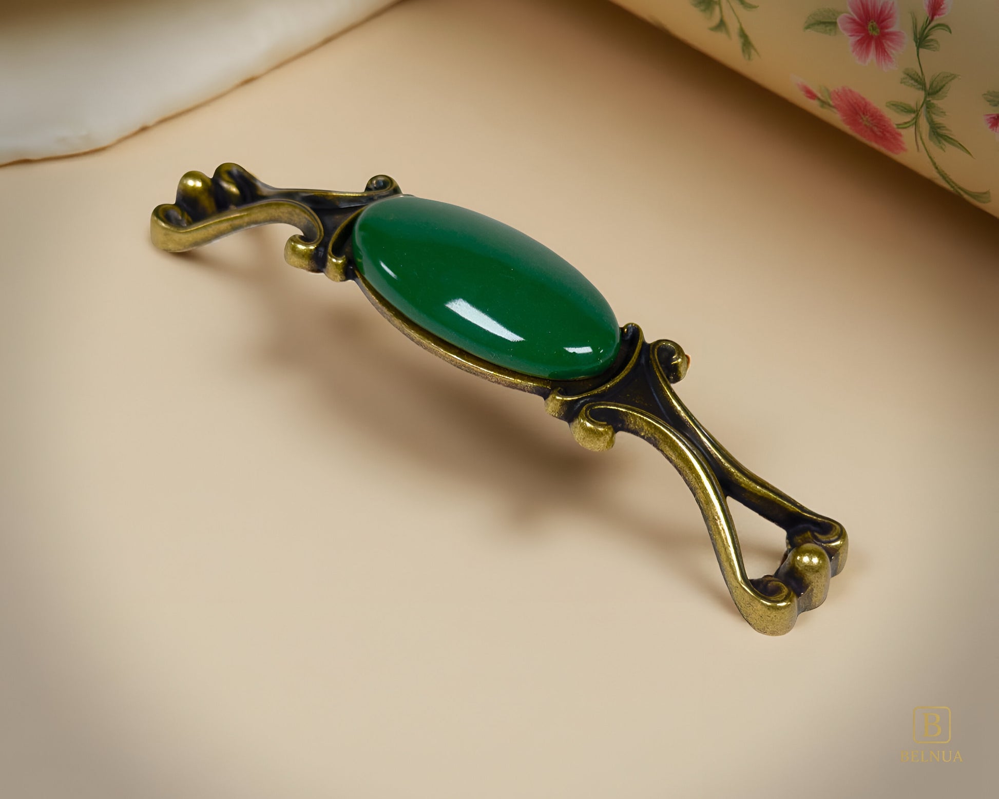 Belnua - Right angled view of Nureya decorative cabinet handle with dark green porcelain and brass base  on a beige surface