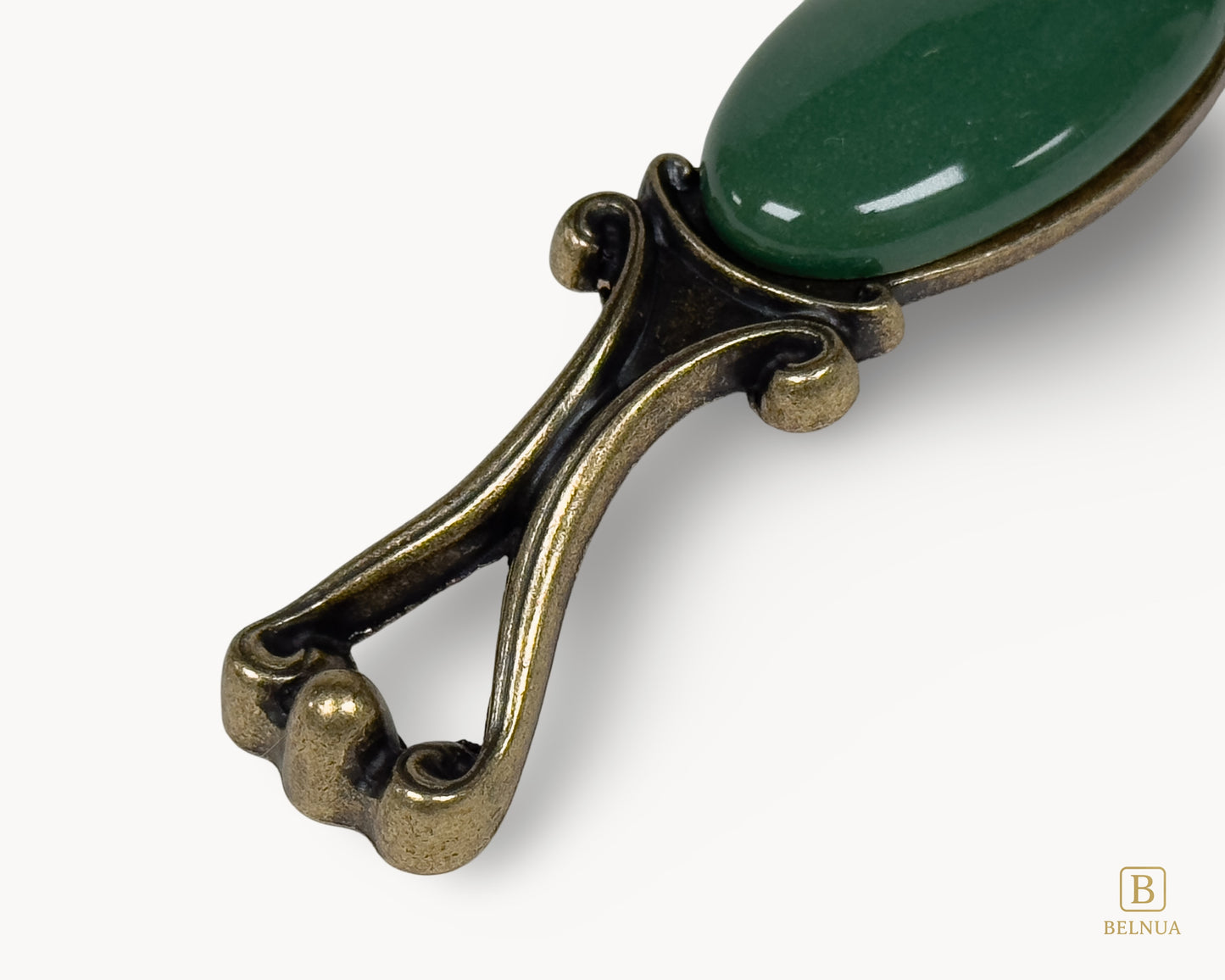 Belnua - Closeup view of Nureya decorative cabinet handle with dark green porcelain and brass base  on a white surface
