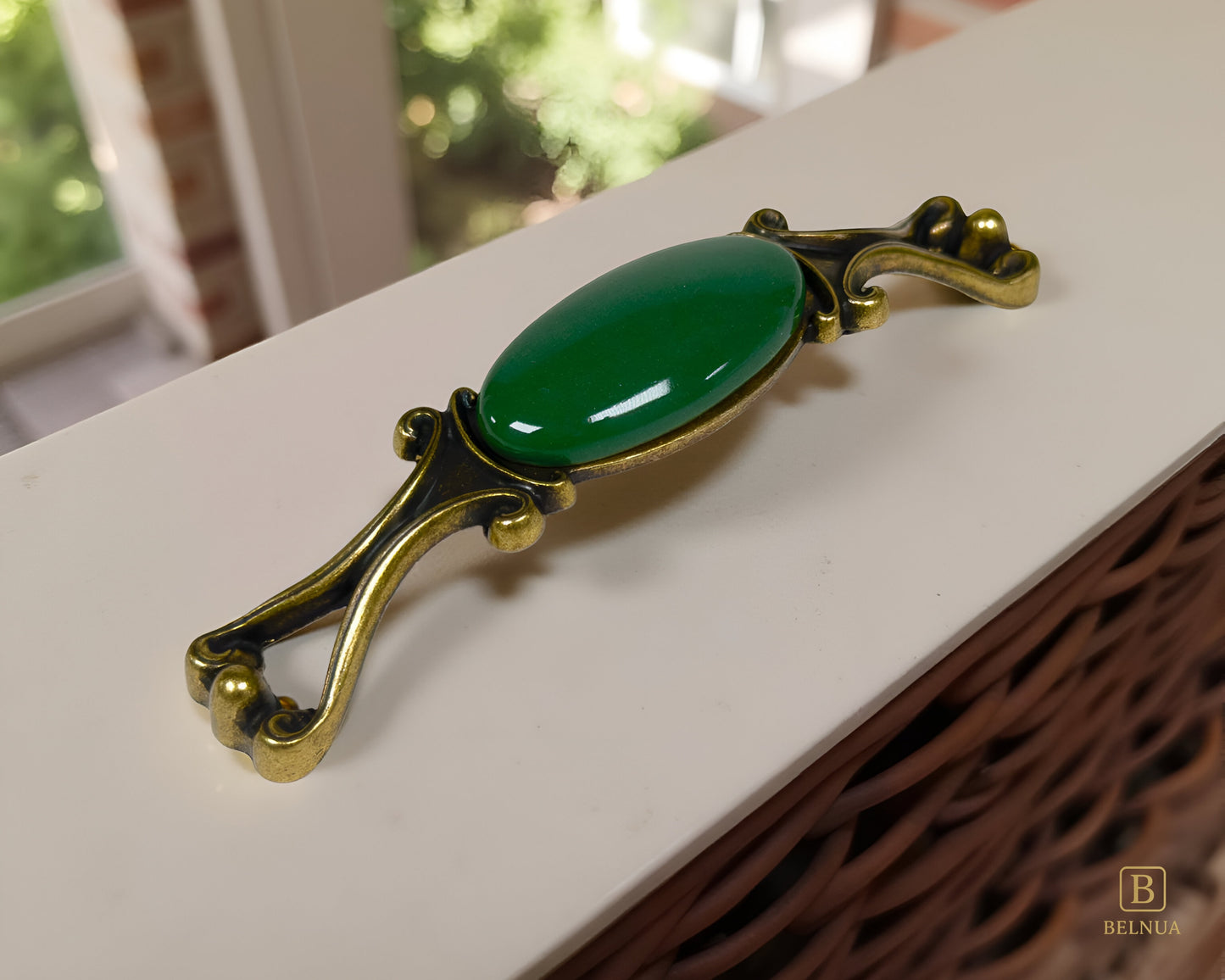 Belnua - A Nureya decorative cabinet handles with dark green porcelain and brass base  on a light grey surface