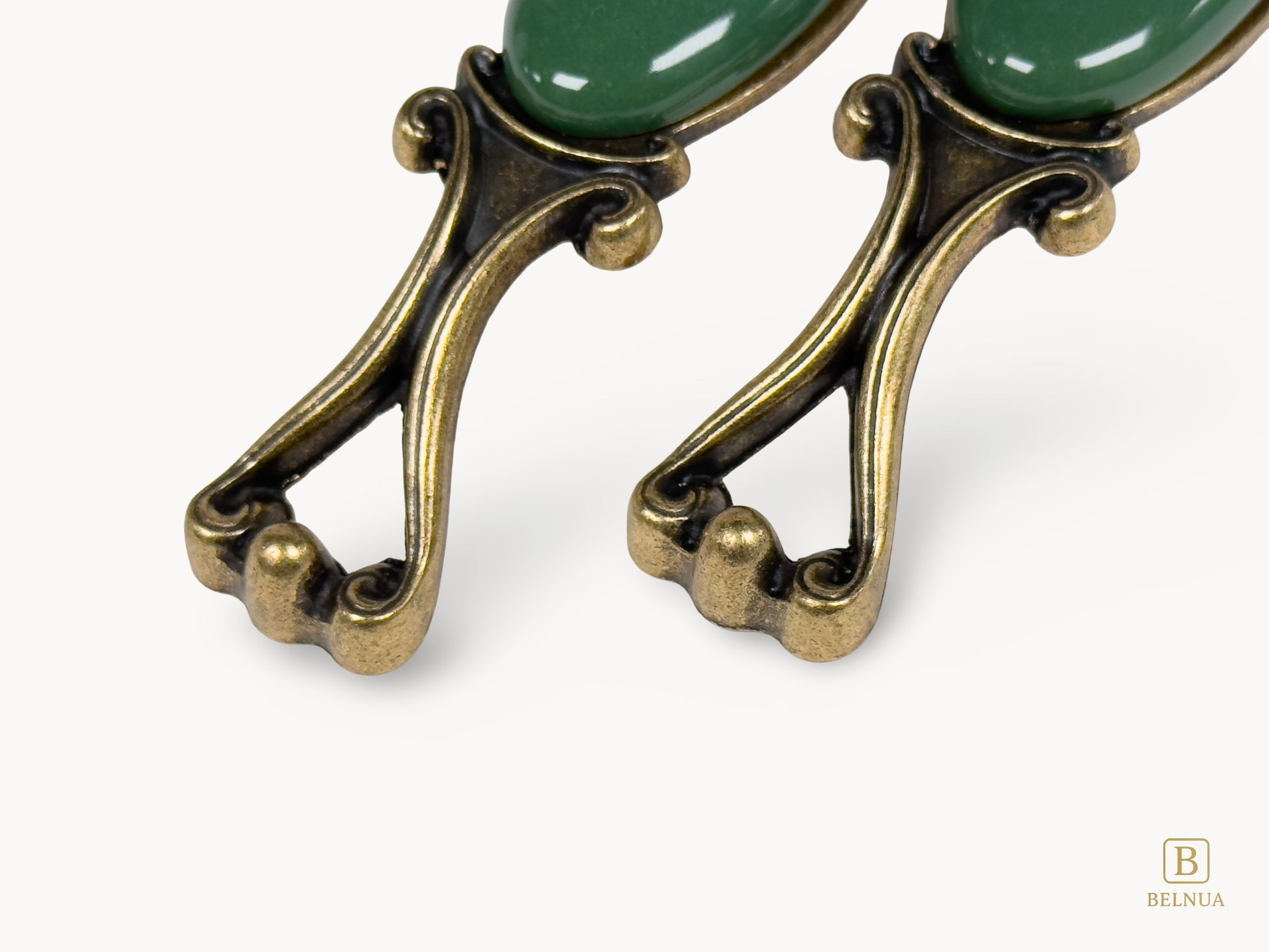 Belnua - Front view of Nureya decorative cabinet handle pair with dark green porcelain and brass base  on a white surface