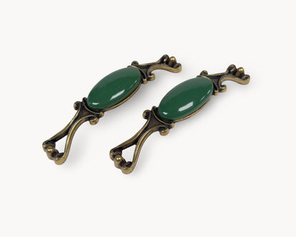 Belnua - Pair of decorative handles with dark green porcelain and brass accents from Nureya collection on a white background
