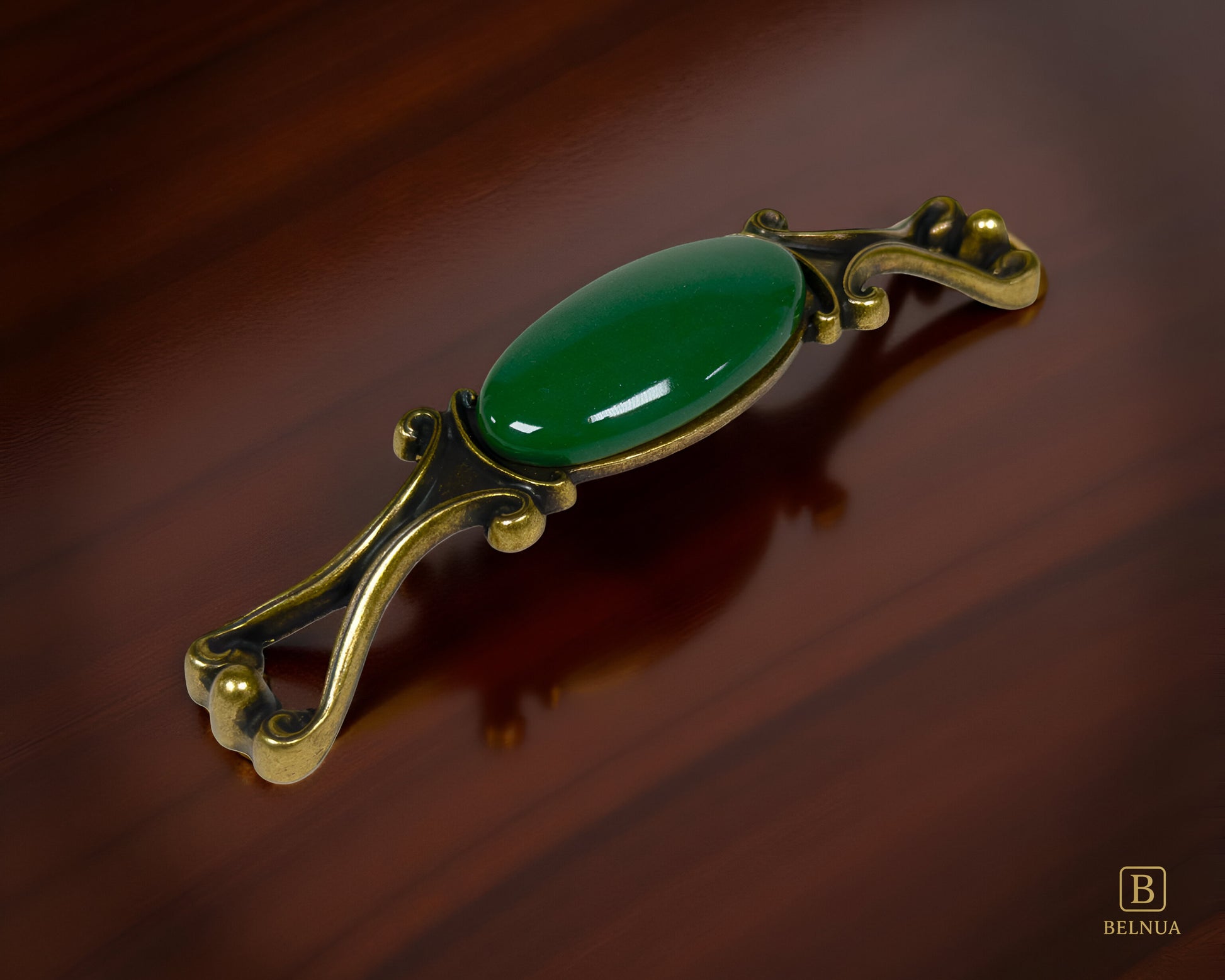 Belnua - Left angled view of Nureya decorative cabinet handle with dark green porcelain and brass base  on a dark walnut table