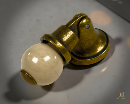 Belnua - Close-up of orange porcelain insert and sculptural antique brass base on marble worktop from Virella collection
