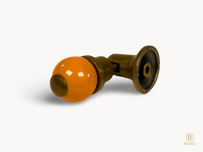 Belnua - Flat lay and back of Belnua’s antique brass knob with orange porcelain showing back fixing