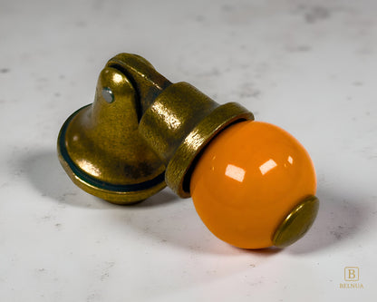 Belnua - VIRELLA knob in antique brass finish with smooth orange porcelain with marble surface