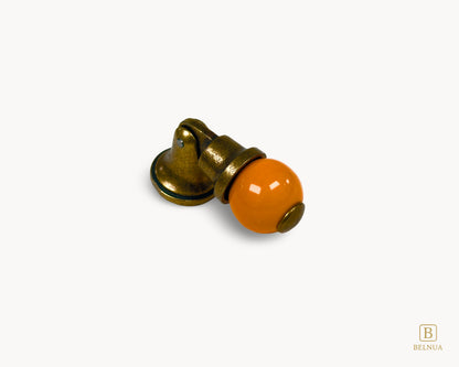 Belnua - Close-up angled view of orange porcelain insert and sculptural antique brass base