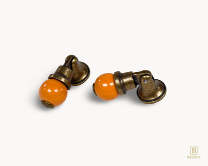 Belnua - Angled photo of orange and antique brass combination on VIRELLA knob pairs