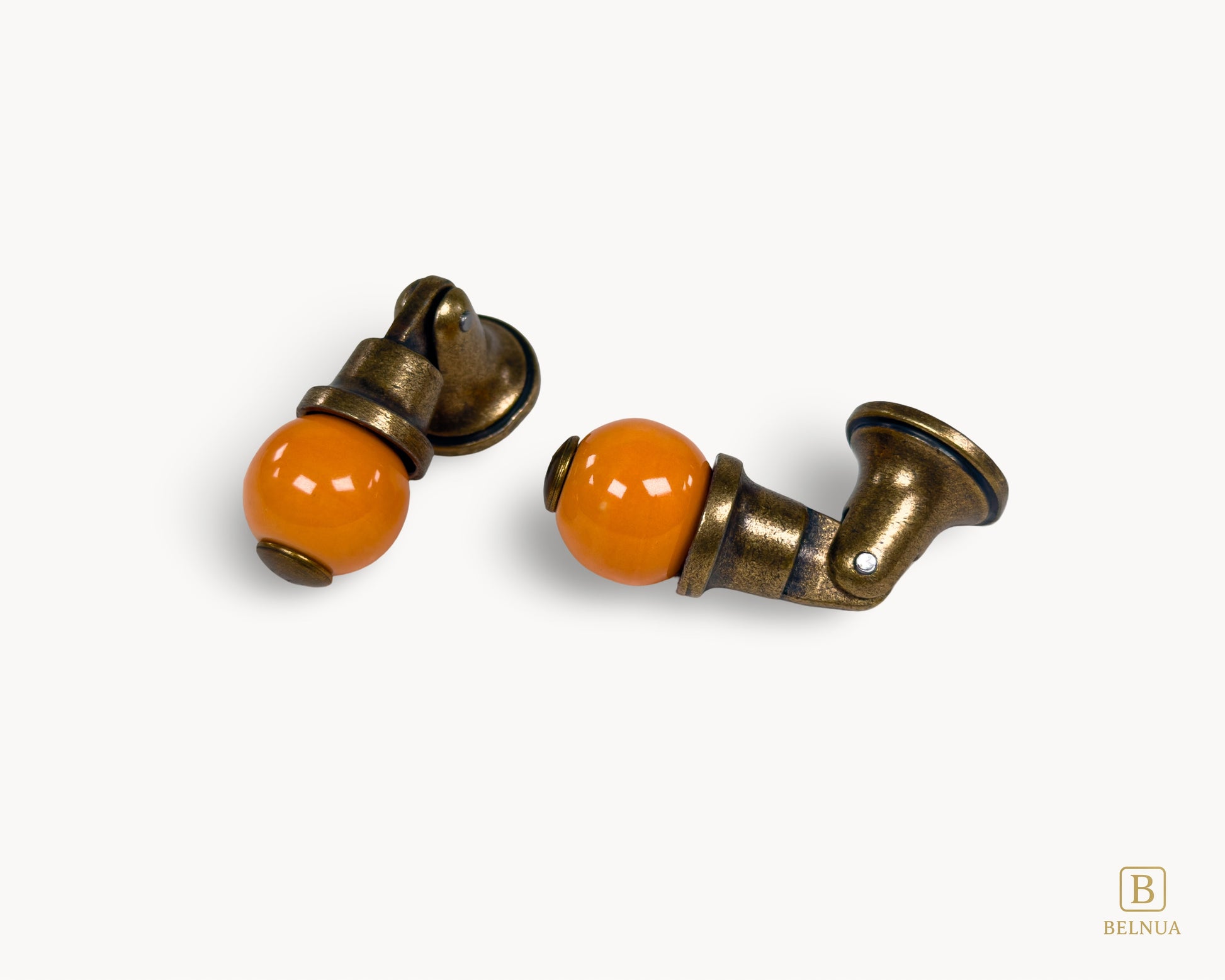 Belnua - Flat lay of Virella antique brass knob pairs with orange porcelain insert