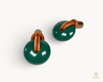 High-resolution shot of two green porcelain furniture knobs with vintage brass accents, ideal for upcycling projects.