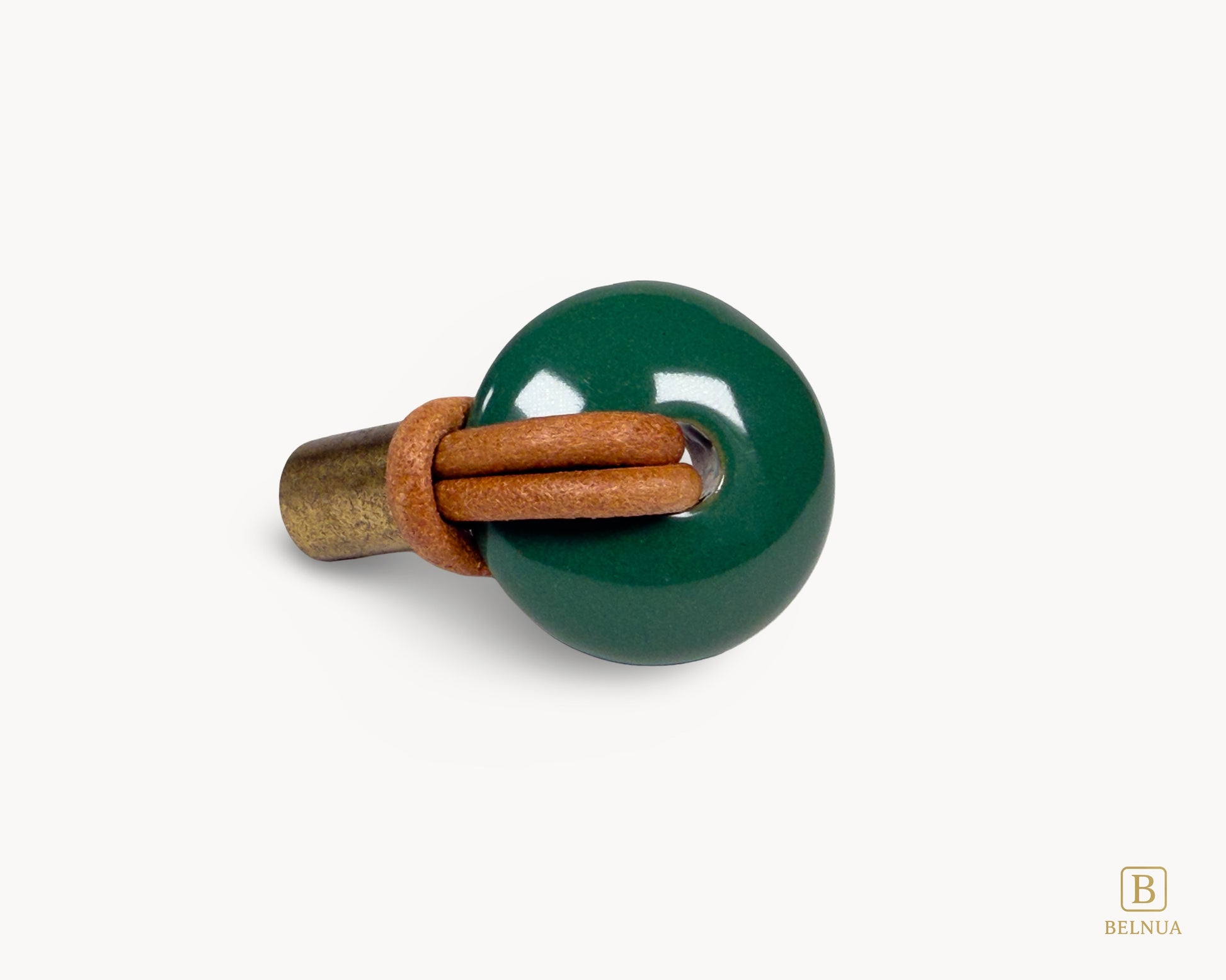 Close-up of green porcelain knob with leather loop and antique brass base