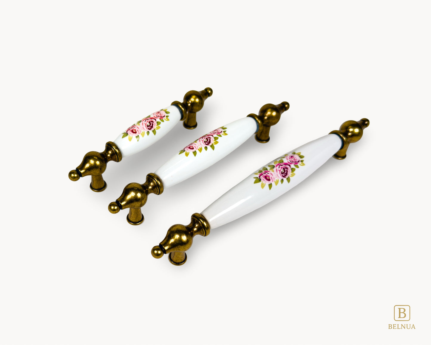 Aligned view of Lumora porcelain cabinet handles in antique brass finish