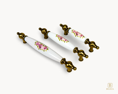 Diagonal arrangement of Lumora antique brass porcelain handles with floral