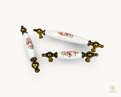 Multiple size layout of Lumora antique brass floral porcelain cabinet handles