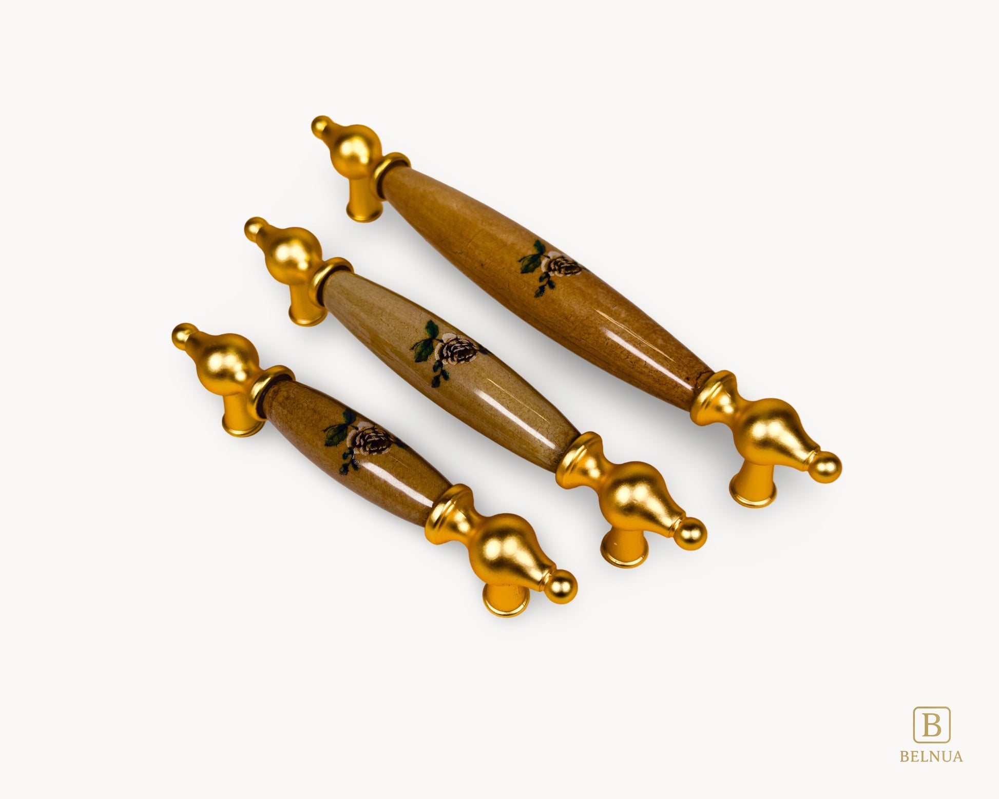 Angled view of Lumora gold porcelain cabinet handles in three sizes