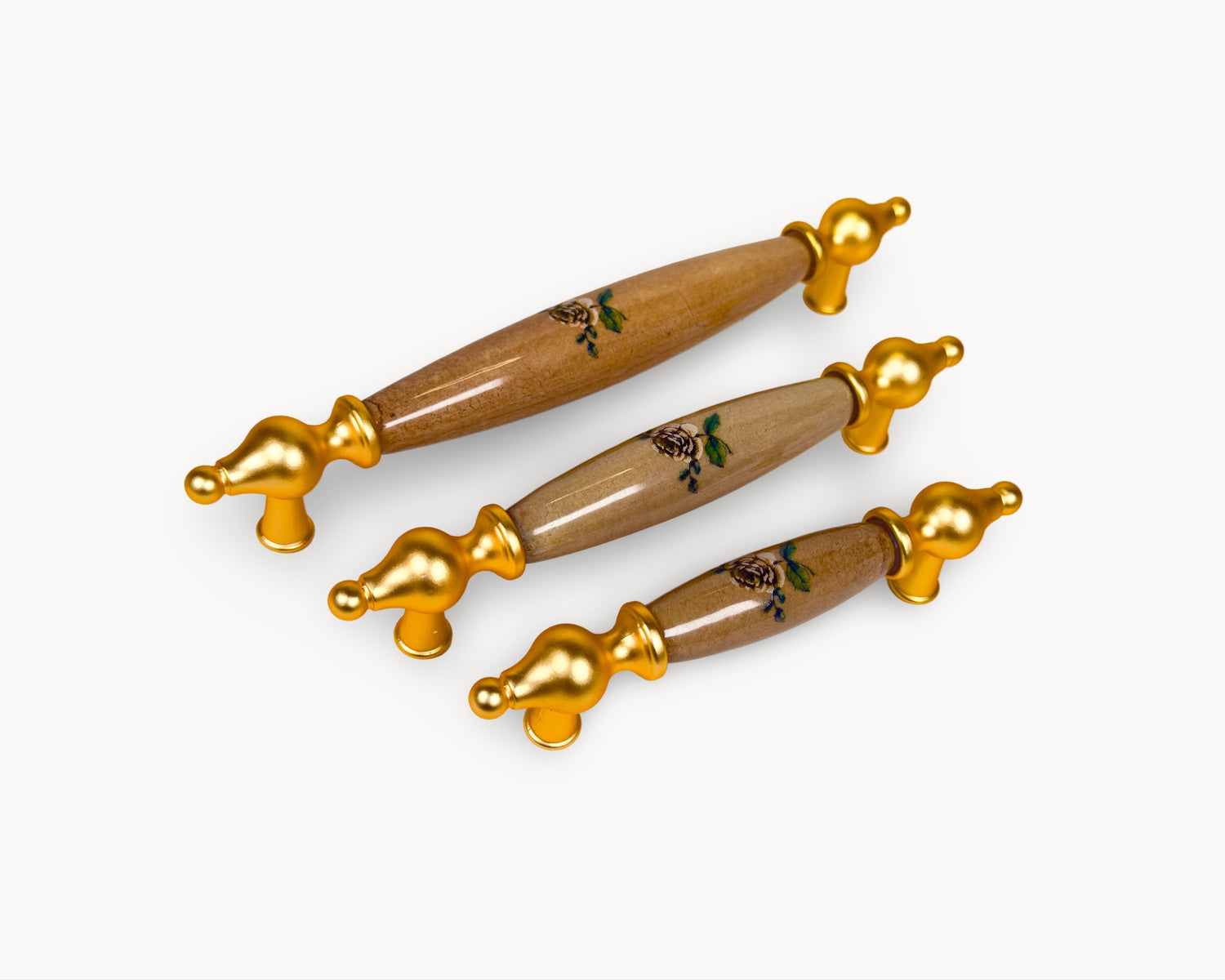 Perspective view of Lumora gold porcelain drawer handles with floral porcelain detail
