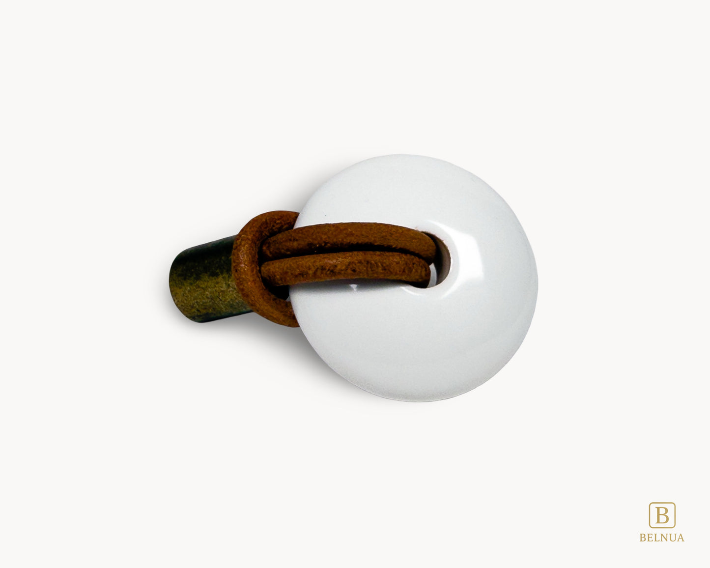 A side installation angle of a white porcelain knob with a weathered antique brass base and brown leather loop.
